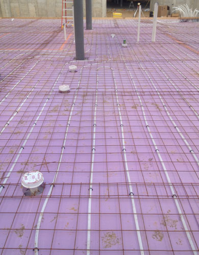Radiant heating system being layed out before concrete is poured over to seal it within the structures floor.